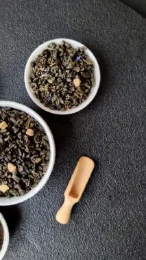 Kuru yeşil çay, soya somunu, knapweed yaprakları koyu beton arka planda.