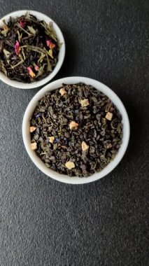 Kuru yeşil çay, soya somunu, knapweed yaprakları koyu beton arka planda.