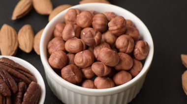 Koyu beton arka planda kabuksuz çiğ fındık.