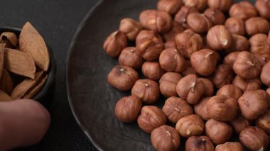 Koyu beton arka planda kabuksuz çiğ fındık.