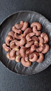 Koyu beton arka planda kabuklu kaju fıstığı.