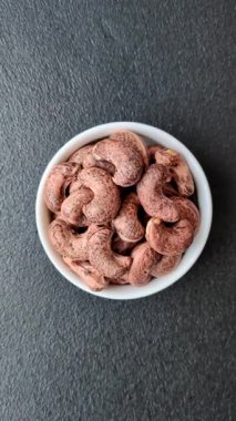 Koyu beton arka planda kabuklu kaju fıstığı.