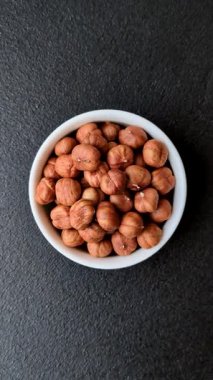 Koyu beton arka planda kabuksuz çiğ fındık.