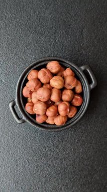 Koyu beton arka planda kabuksuz çiğ fındık.