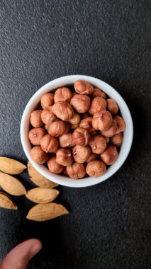 Koyu beton arka planda kabuksuz çiğ fındık.