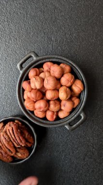 Koyu beton arka planda kabuksuz çiğ fındık.