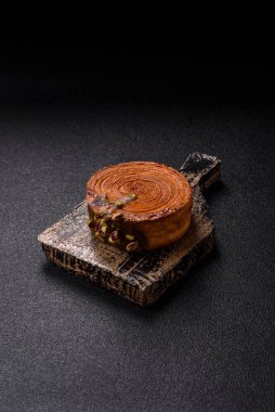 Yuvarlak poğaçalı kruvasan, şam fıstığı dolgulu veya koyu beton zemin üzerinde New York rulosu.