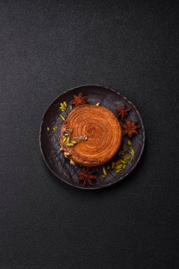 Yuvarlak poğaçalı kruvasan, şam fıstığı dolgulu veya koyu beton zemin üzerinde New York rulosu.