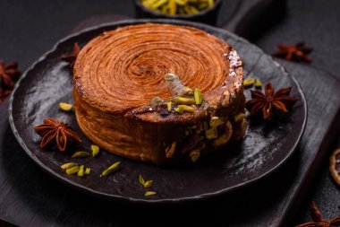 Yuvarlak poğaçalı kruvasan, şam fıstığı dolgulu veya koyu beton zemin üzerinde New York rulosu.