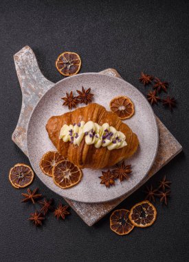 Koyu beton arka planda böğürtlenli taze kruvasan.