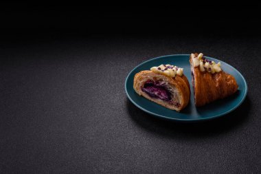 Koyu beton arka planda böğürtlenli taze kruvasan.