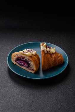 Koyu beton arka planda böğürtlenli taze kruvasan.