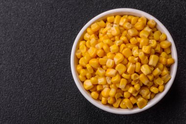 Koyu beton arka planda kasede tatlı sarı mısır konservesi