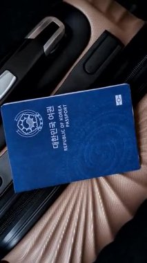 Bir bavulun üzerinde bir Güney Kore vatandaşının uluslararası pasaportu havaalanından kalkış, uluslararası seyahat.