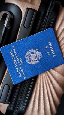 Bir bavulda Kuzey Kore vatandaşının uluslararası pasaportu havaalanından kalkış, uluslararası seyahat.