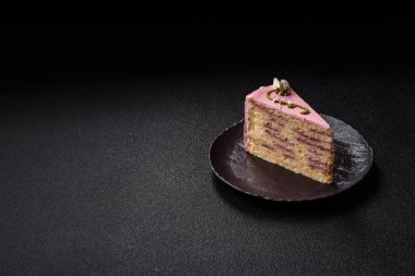 Koyu beton arka planda çilek aromalı pembe katmanlı bir pasta.