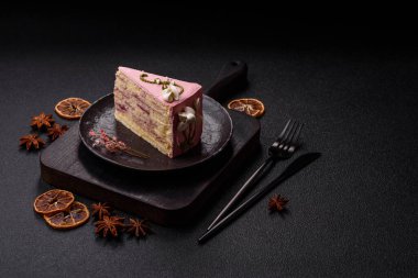 Koyu beton arka planda çilek aromalı pembe katmanlı bir pasta.