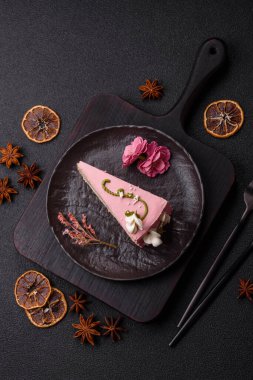 Koyu beton arka planda çilek aromalı pembe katmanlı bir pasta.