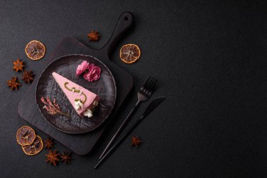 Koyu beton arka planda çilek aromalı pembe katmanlı bir pasta.