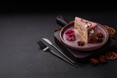 Koyu beton arka planda çilek aromalı pembe katmanlı bir pasta.