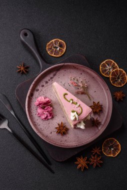 Koyu beton arka planda çilek aromalı pembe katmanlı bir pasta.