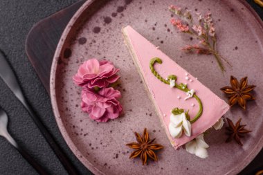 Koyu beton arka planda çilek aromalı pembe katmanlı bir pasta.