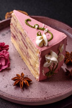 Koyu beton arka planda çilek aromalı pembe katmanlı bir pasta.