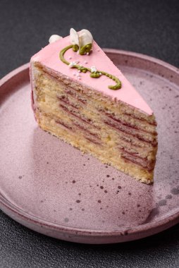 Koyu beton arka planda çilek aromalı pembe katmanlı bir pasta.