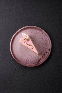Koyu beton arka planda çilek aromalı pembe katmanlı bir pasta.