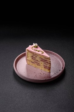 Koyu beton arka planda çilek aromalı pembe katmanlı bir pasta.