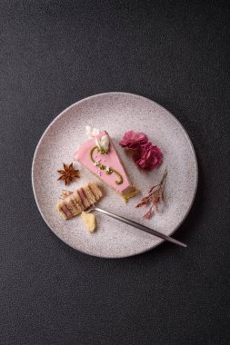 Koyu beton arka planda çilek aromalı pembe katmanlı bir pasta.