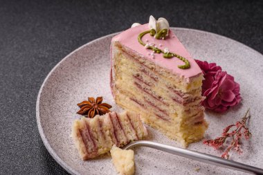 Koyu beton arka planda çilek aromalı pembe katmanlı bir pasta.
