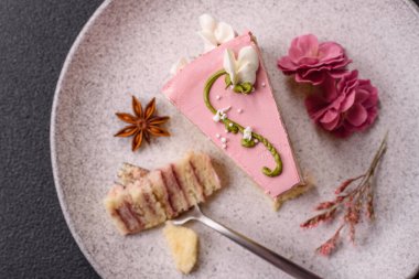 Koyu beton arka planda çilek aromalı pembe katmanlı bir pasta.