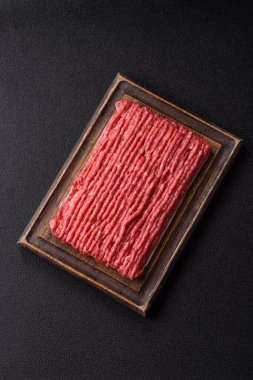 Koyu beton arka planda çiğ et veya tuzlu ve baharatlı domuz eti.