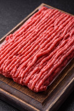 Koyu beton arka planda çiğ et veya tuzlu ve baharatlı domuz eti.