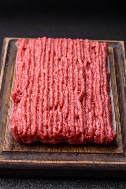 Koyu beton arka planda çiğ et veya tuzlu ve baharatlı domuz eti.
