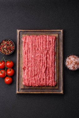Koyu beton arka planda çiğ et veya tuzlu ve baharatlı domuz eti.