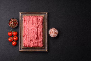 Koyu beton arka planda çiğ et veya tuzlu ve baharatlı domuz eti.
