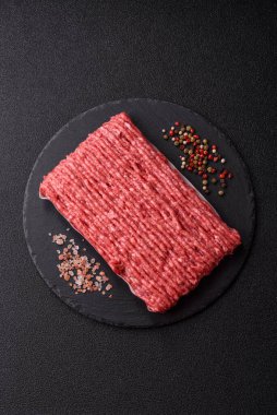 Koyu beton arka planda çiğ et veya tuzlu ve baharatlı domuz eti.