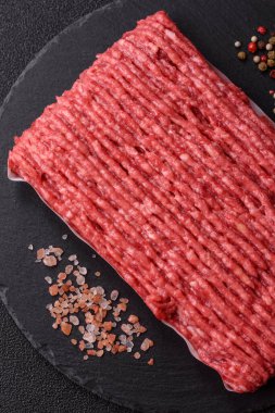 Koyu beton arka planda çiğ et veya tuzlu ve baharatlı domuz eti.