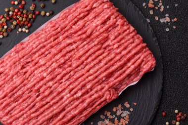 Koyu beton arka planda çiğ et veya tuzlu ve baharatlı domuz eti.