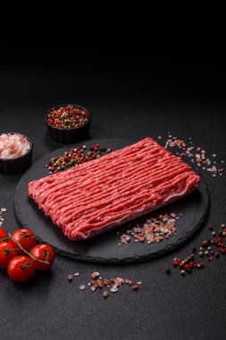 Koyu beton arka planda çiğ et veya tuzlu ve baharatlı domuz eti.