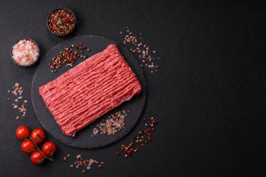 Koyu beton arka planda çiğ et veya tuzlu ve baharatlı domuz eti.