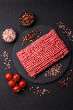 Koyu beton arka planda çiğ et veya tuzlu ve baharatlı domuz eti.