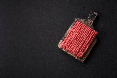 Koyu beton arka planda çiğ et veya tuzlu ve baharatlı domuz eti.