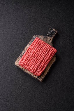 Koyu beton arka planda çiğ et veya tuzlu ve baharatlı domuz eti.