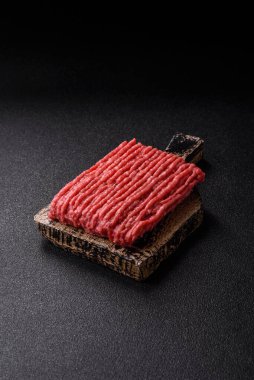 Koyu beton arka planda çiğ et veya tuzlu ve baharatlı domuz eti.