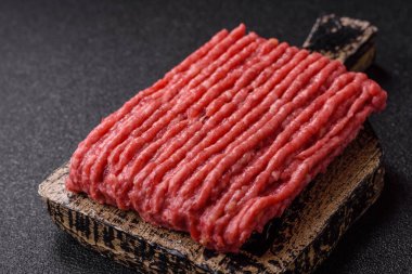 Koyu beton arka planda çiğ et veya tuzlu ve baharatlı domuz eti.