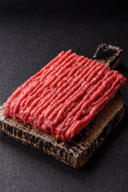 Koyu beton arka planda çiğ et veya tuzlu ve baharatlı domuz eti.