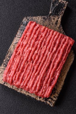 Koyu beton arka planda çiğ et veya tuzlu ve baharatlı domuz eti.